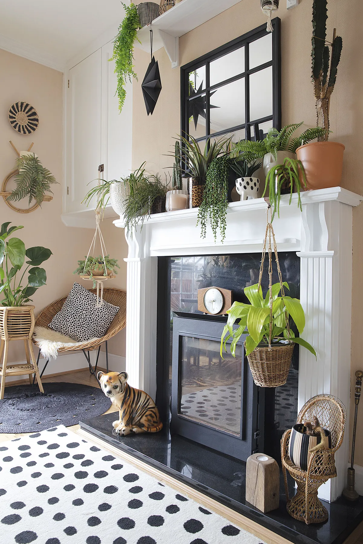 ‘I painted the wooden fire surround black to start with, but it looks miles better white, as it makes the plants stand out more,’ says Leanne. The Crittall- style mirror is from Home Bargains and the walls are painted in Johnstone’s Oatcake
