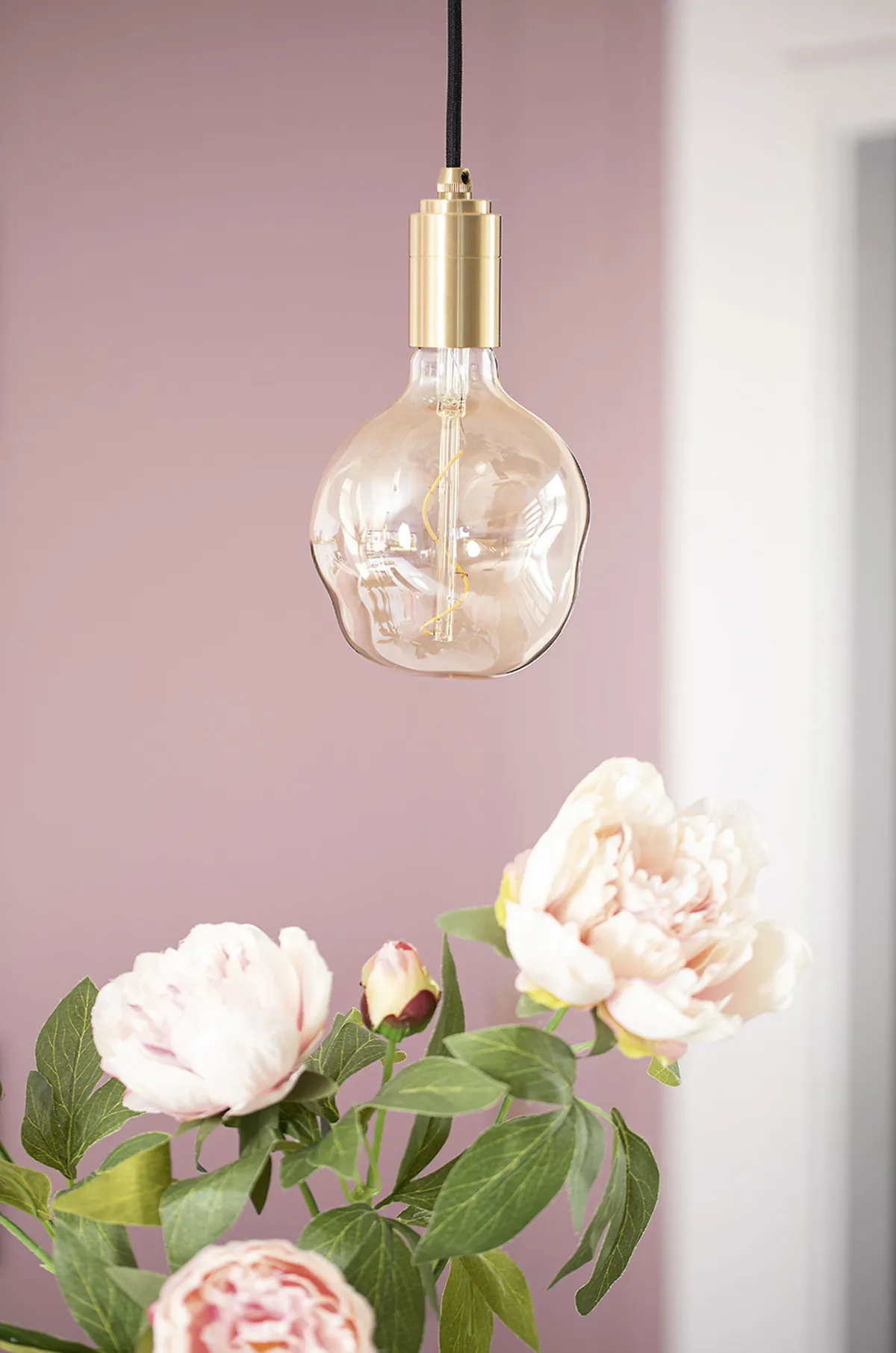 Gold pendant light in pink kitchen