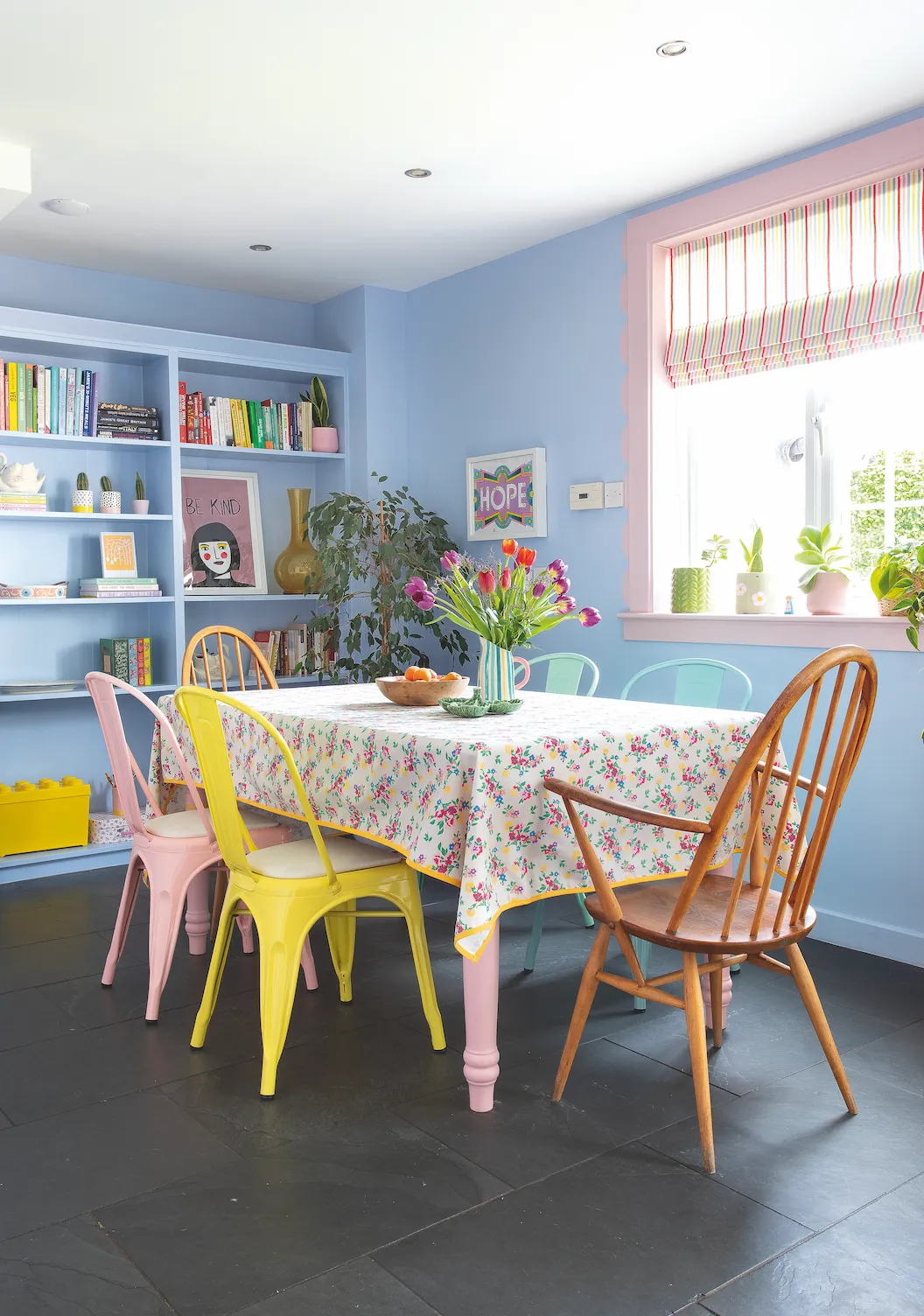 Cath Kidston patterns and flashes of mustard give a hint of warmth to the pastels, complementing the pink window frame and colourful chairs from Sklum. Heather already had the farmhouse table, which she painted pink