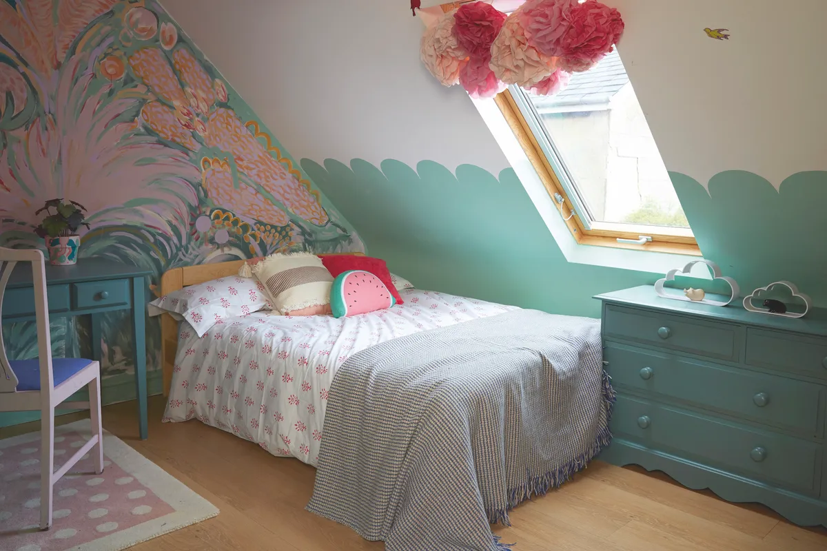 Ffion’s bedroom is a colourful and cosy space, with a nature-inspired mural at one end and scalloped design on the side walls