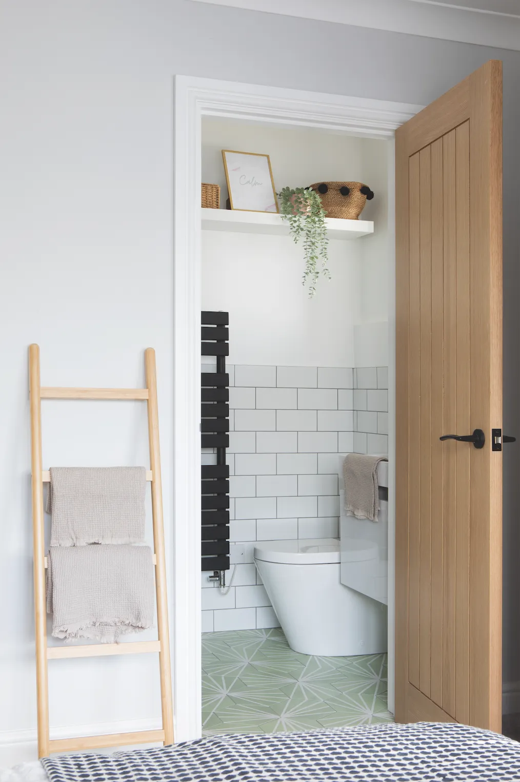 Becca has packed a lot of style into the petite en suite – black accents echo the décor throughout her home, while green floor tiles match the bedroom walls for a sense of flow between the two rooms