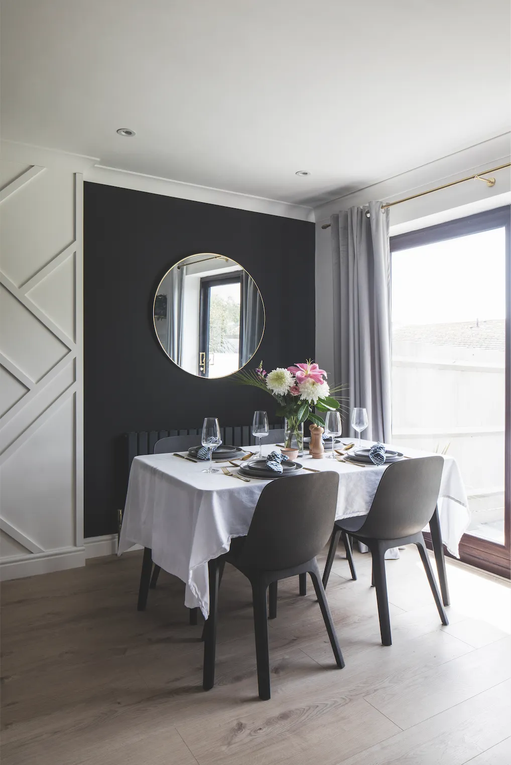 A white geometric panel between the dark walls zones the open-plan space, and Becca has brightened up the black wall behind the dining area with a round brass mirror. ‘It looks better in this alcove as it reflects the kitchen, rather than the TV,’ says Becca