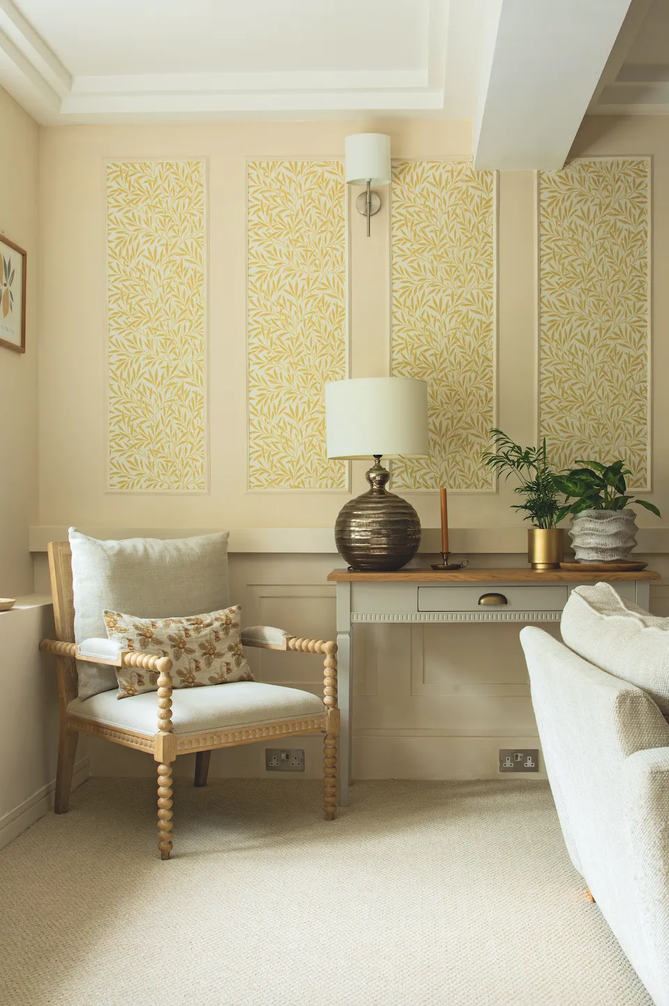 Wallpapering inside of the DIY panelling with a tonal leaf design adds a bit of pattern and lifts this corner of the living room