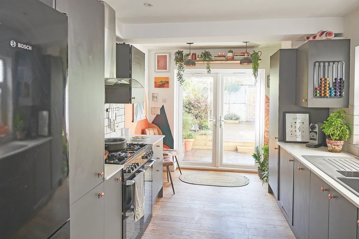 The couple couldn’t afford an extension, so instead boosted space in the kitchen by taking out an understairs cupboard and choosing streamlined grey cabinets