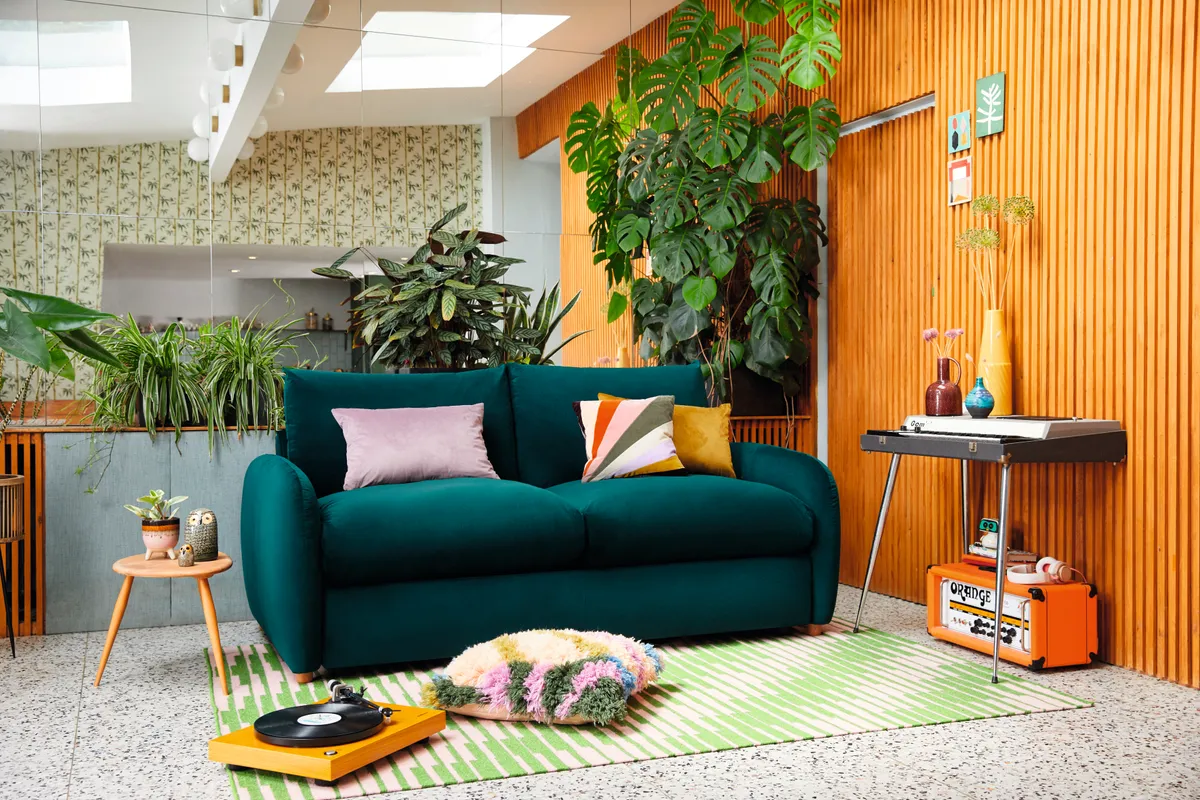 Teal sofa in a front room with orange panelled walls