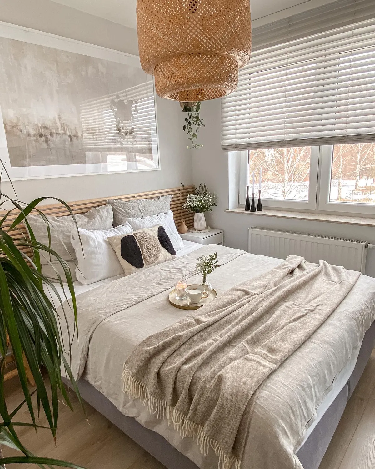 beige bedroom with rattan lighting and houseplants