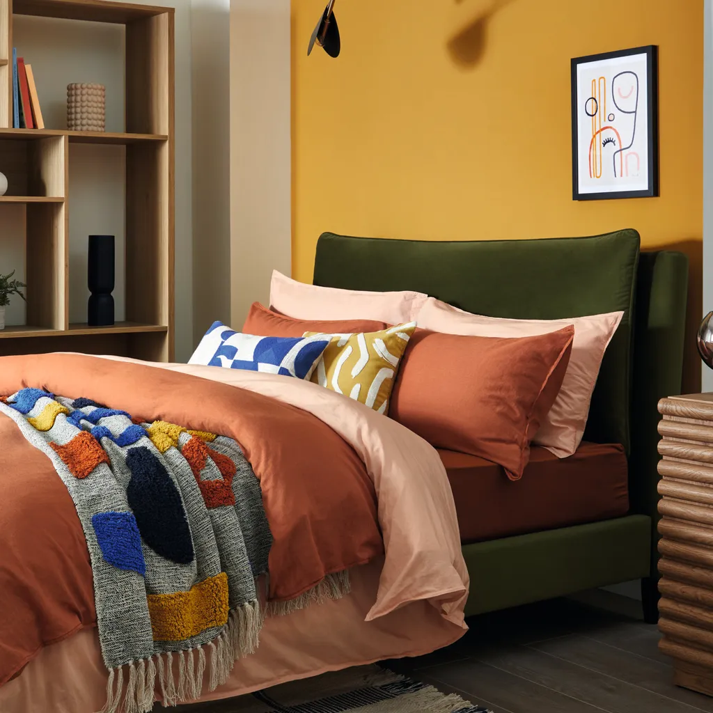 Skylar pillow back bed in Olive Velvet, from £399; cotton linen duvet set in Terracotta, from £40; cotton muslin duvet set in Apricot, from £35; tufted brights geo throw, £45; Elements woven check rug, £125, all Dunelm