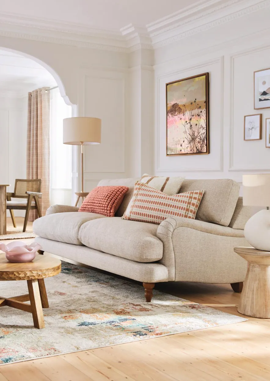 Avery large sofa in Cream chunky weave, £1,675; Peach Pink Eva textured cushion, £18; Global bobble cushion in Orange, £24; natural mango wood trumpet side table, £150; Reuben table lamp in Ivory Cream, £70, all Next