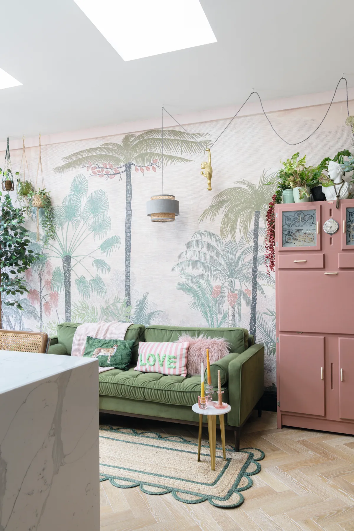 Green velvet sofa and plant wallpaper