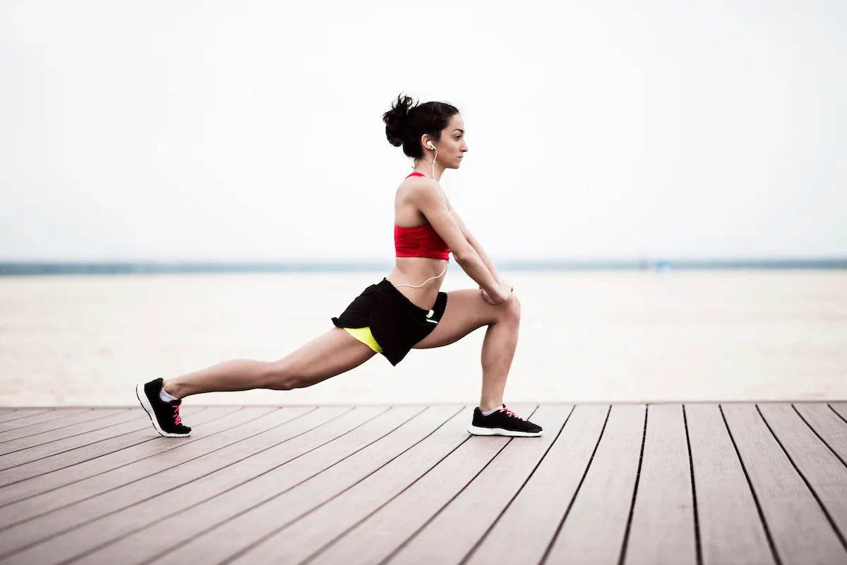 female runner stretching in a lunge