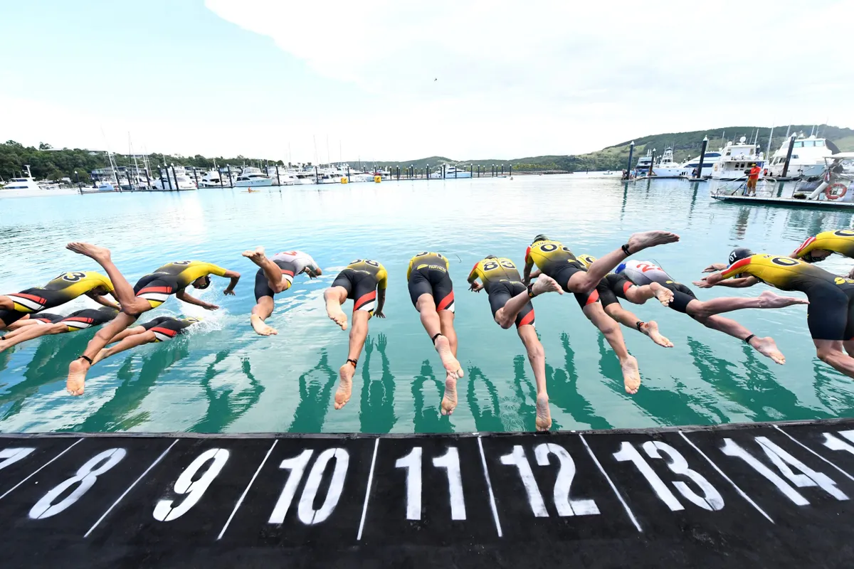 A behind shot of the male pro triathletes diving into the water at the debut Super League Triathlon in Hamilton Island, Australia, 2017