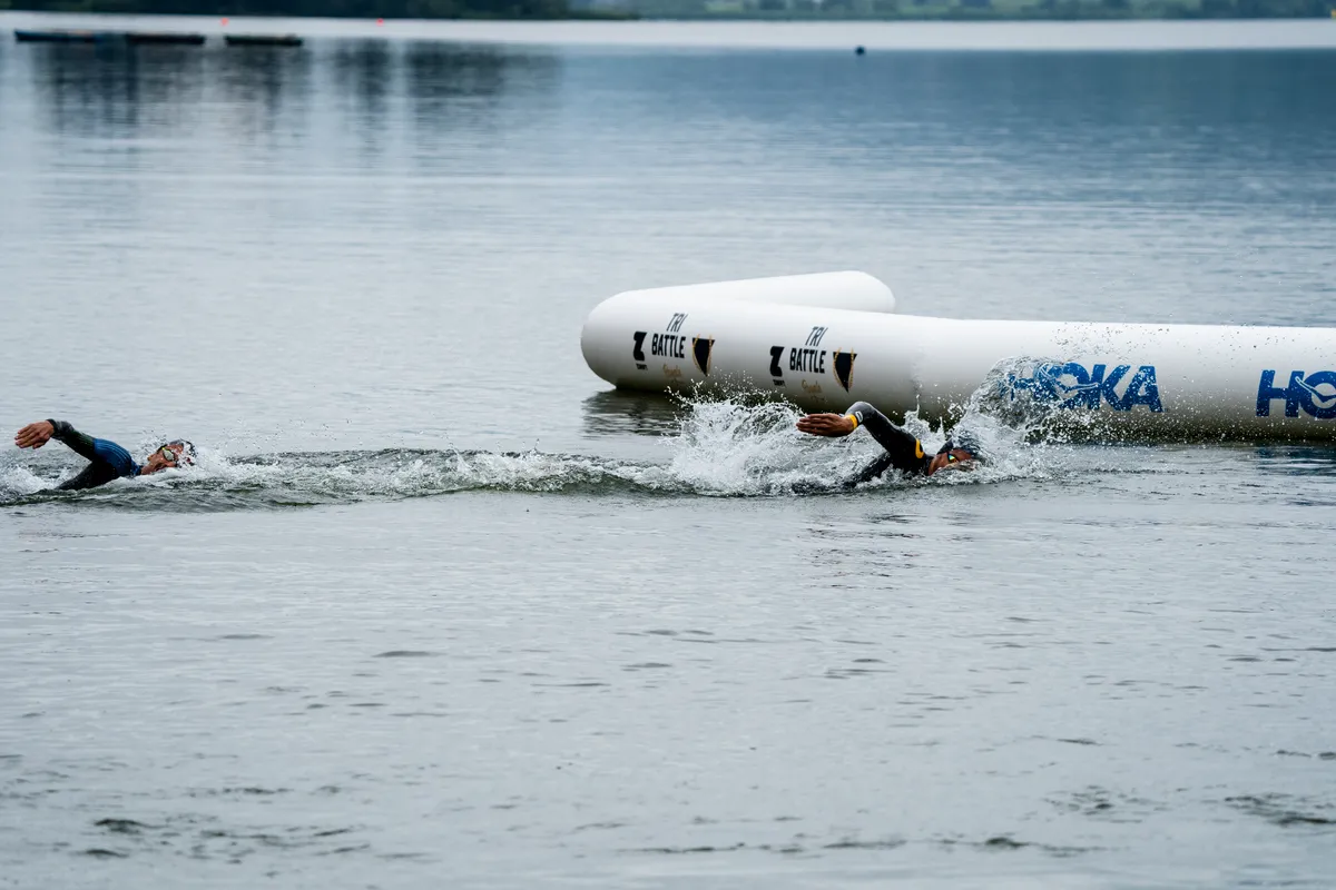 Sanders chases down Jan during the four swim laps in the freshwater Großer Alpsee lake.