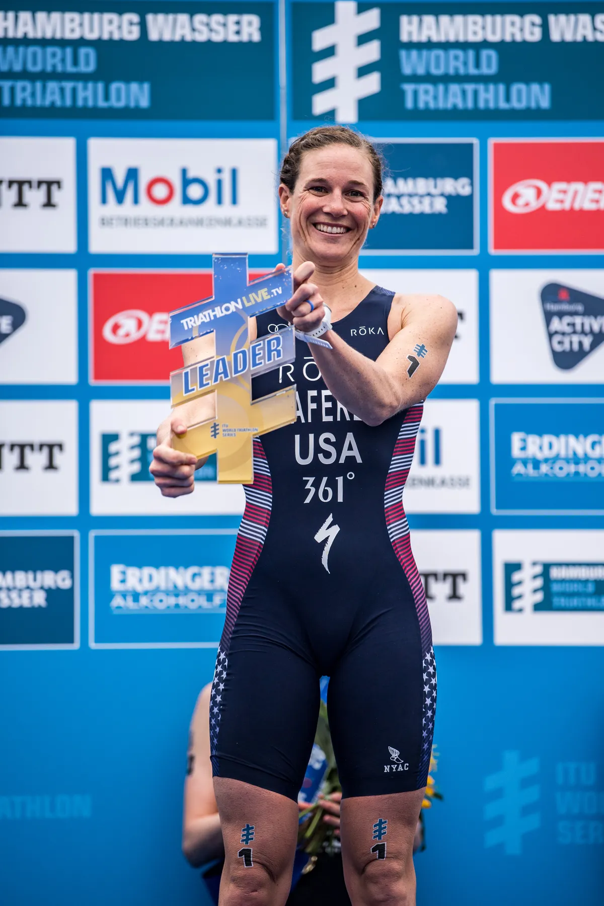HAMBURG, GERMANY - JULY 06: (EDITORS NOTE: Image has been digitally enhanced.) Katie Zaferes of USA (world leader) poses with the trophy on the podium after the ITU World Triathlon Elite women sprint distance during the Hamburg Wasser World Triathlon on July 06, 2019 in Hamburg, Germany. (Photo by Lukas Schulze/Getty Images for IRONMAN)
