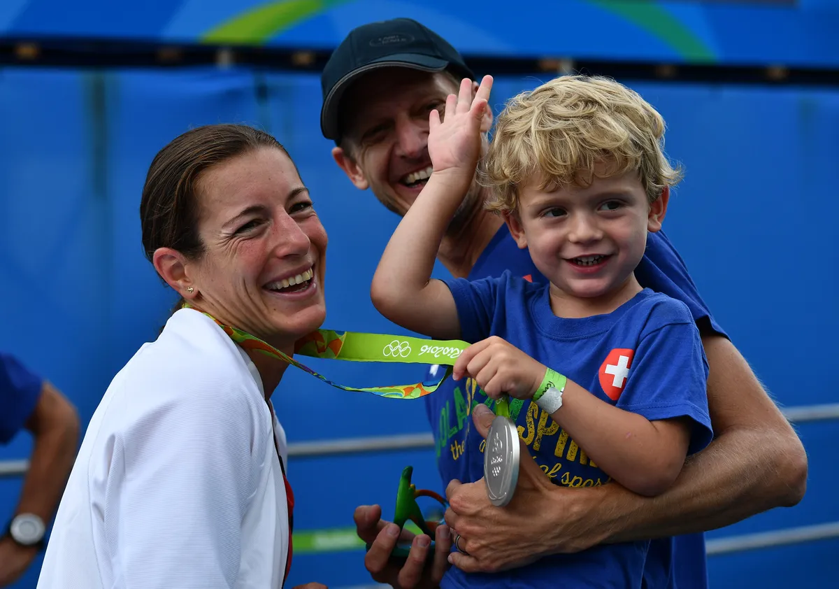 Switzerland's Nicola Spirig (L) celebrates with her family after receiving the silver medal in the women's triathlon at Fort Copacabana during the Rio 2016 Olympic Games in Rio de Janeiro on August 20, 2016. / AFP / Leon NEAL (Photo credit should read LEON NEAL/AFP via Getty Images)