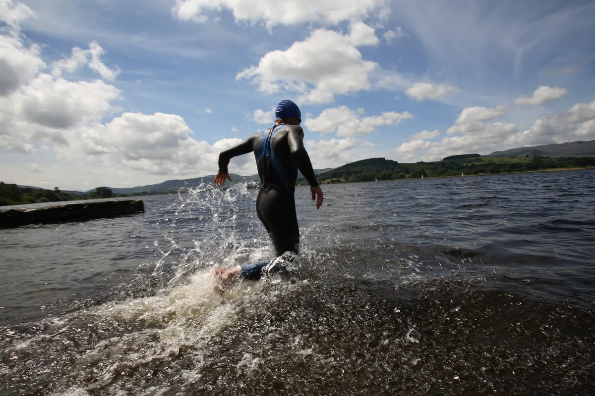 Triathlete swimmer running into water