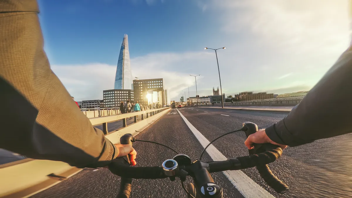 POV of a cyclist biking over a bridge in London with the Shard ahead of him