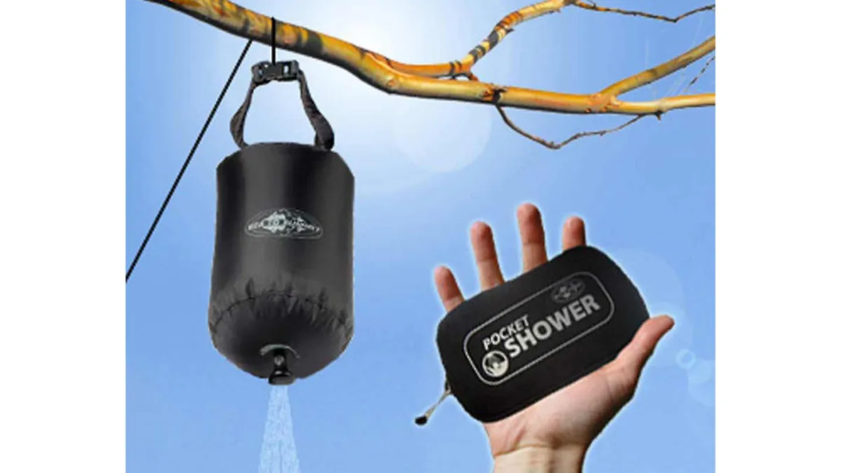 Pocket Shower bag hanging from tree branch with hand holding storage pouch against sky