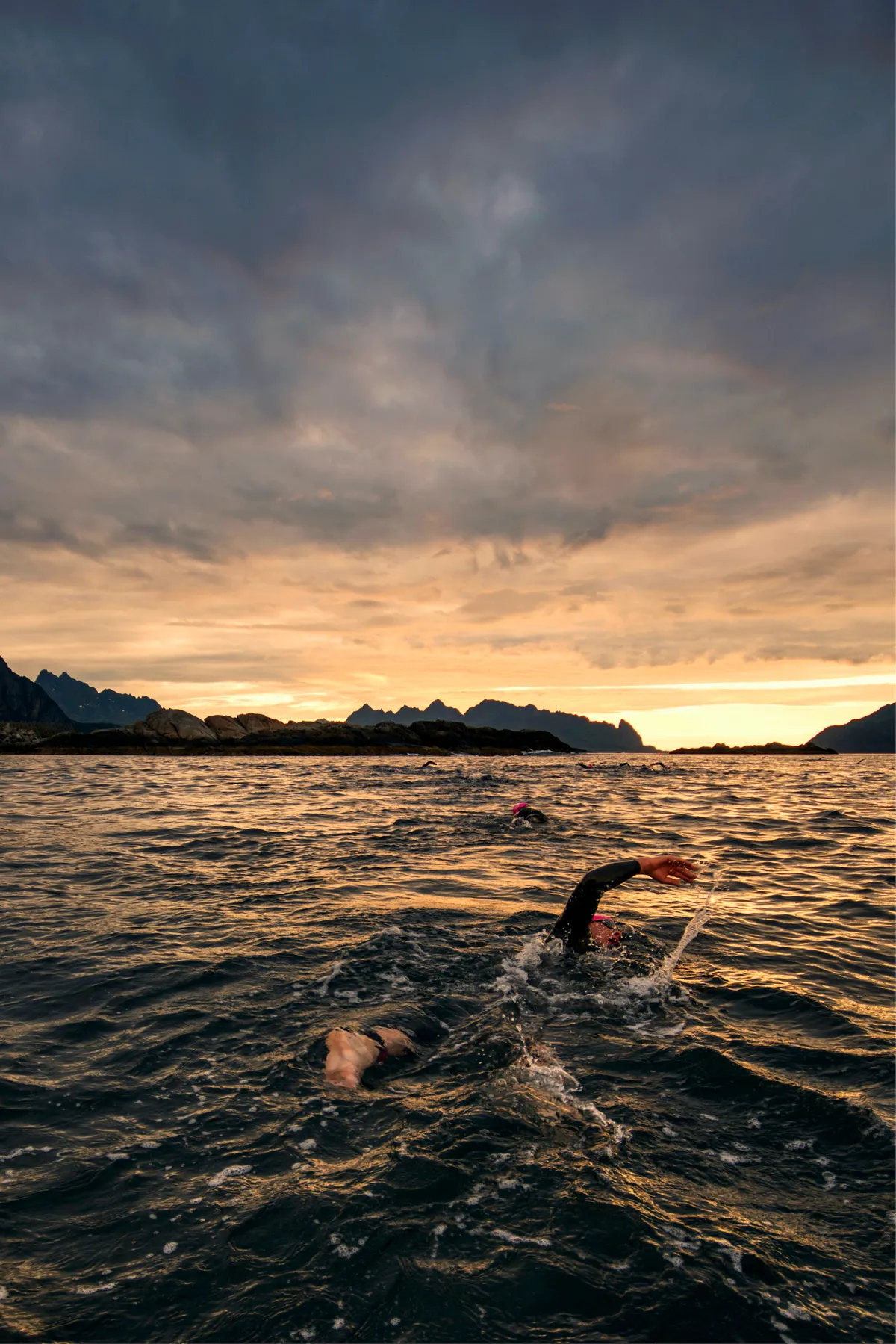 Triathletes swim during the Lofoten Triathlon in Norway