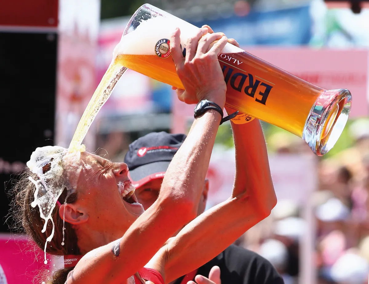 ROTH, GERMANY - JULY 10: Chrissie Wellington of England enjoys a glas of beer after winning the Challenge Roth Triathlon with a new long distance world record on July 10, 2011 in Roth, Germany. (Photo by Alexander Hassenstein/Getty Images for Challenge Roth) *** Local Caption *** Chrissie Wellington
