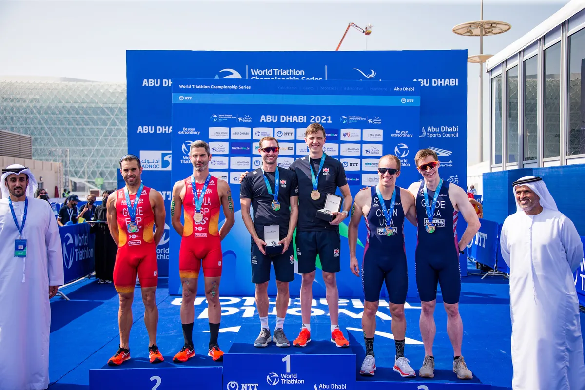 Dave Ellis stands on the podium after becoming a paratriathlon world champion