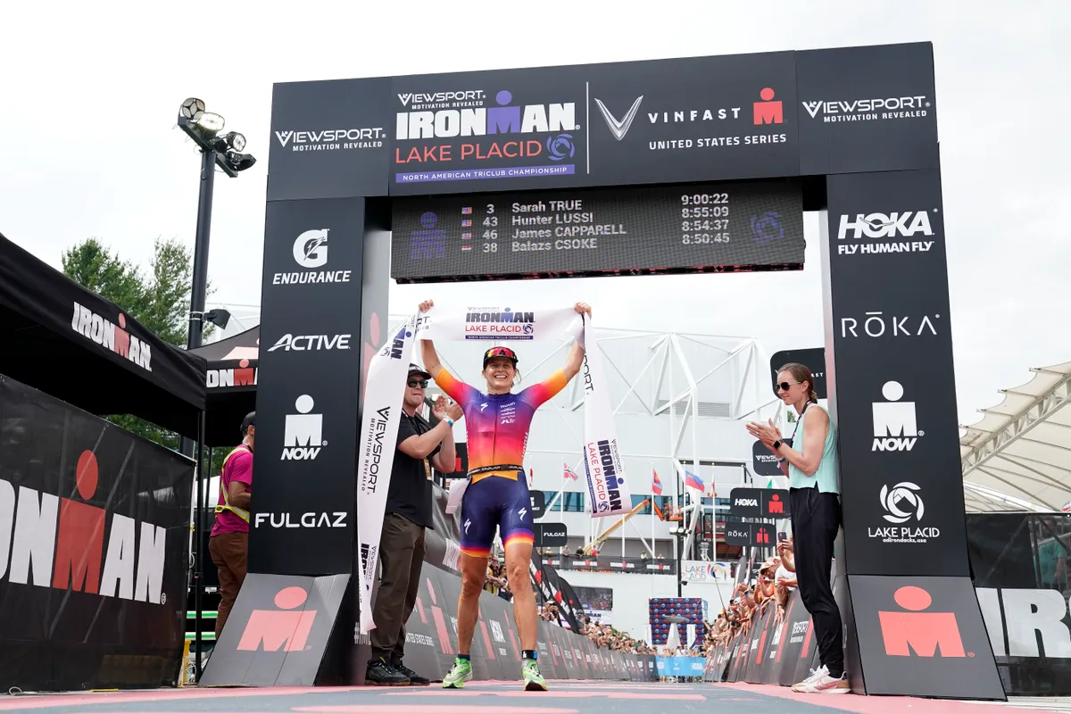 LAKE PLACID, NEW YORK - JULY 24: Sarah True of the United States celebrates celebrates as she crosses the finish line to win the Pro Women's Division of IRONMAN Lake Placid North American TriClub Championship on July 24, 2022 in Lake Placid, New York. (Photo by Patrick McDermott/Getty Images for IRONMAN)