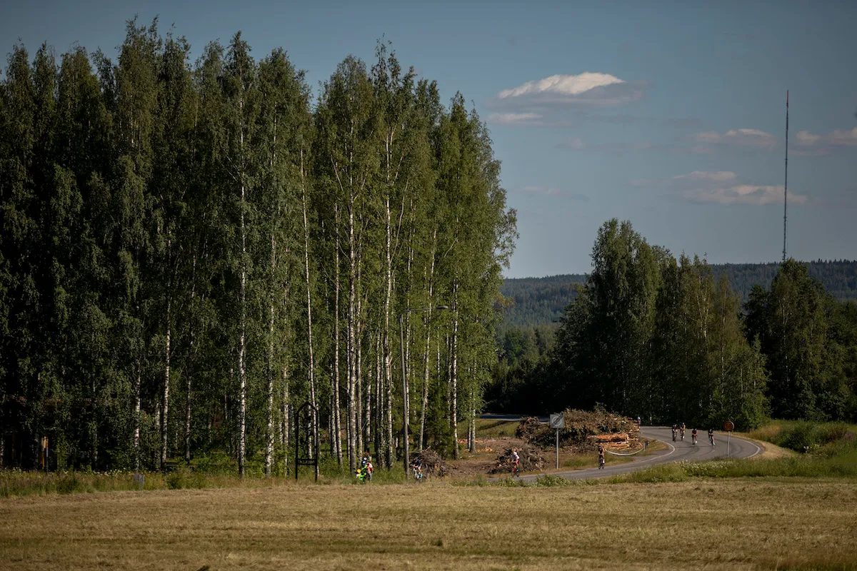 Athletes ride past tall birch forests during the bike leg of the 2021 Ironman 70.3 Lahti, Finland