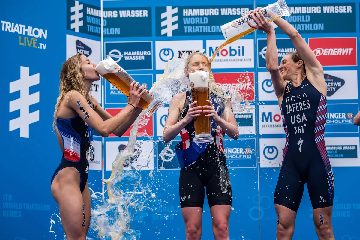 Katie Zaferes pours beer over Non Stanford on the podium