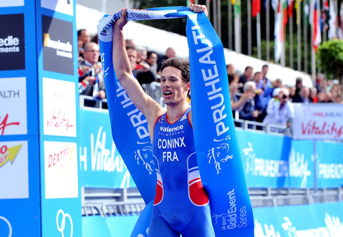 Frenchman Dorian Coninx lifts the winner's tape above his head as he celebrates becoming the 2013 world junior triathlon champion
