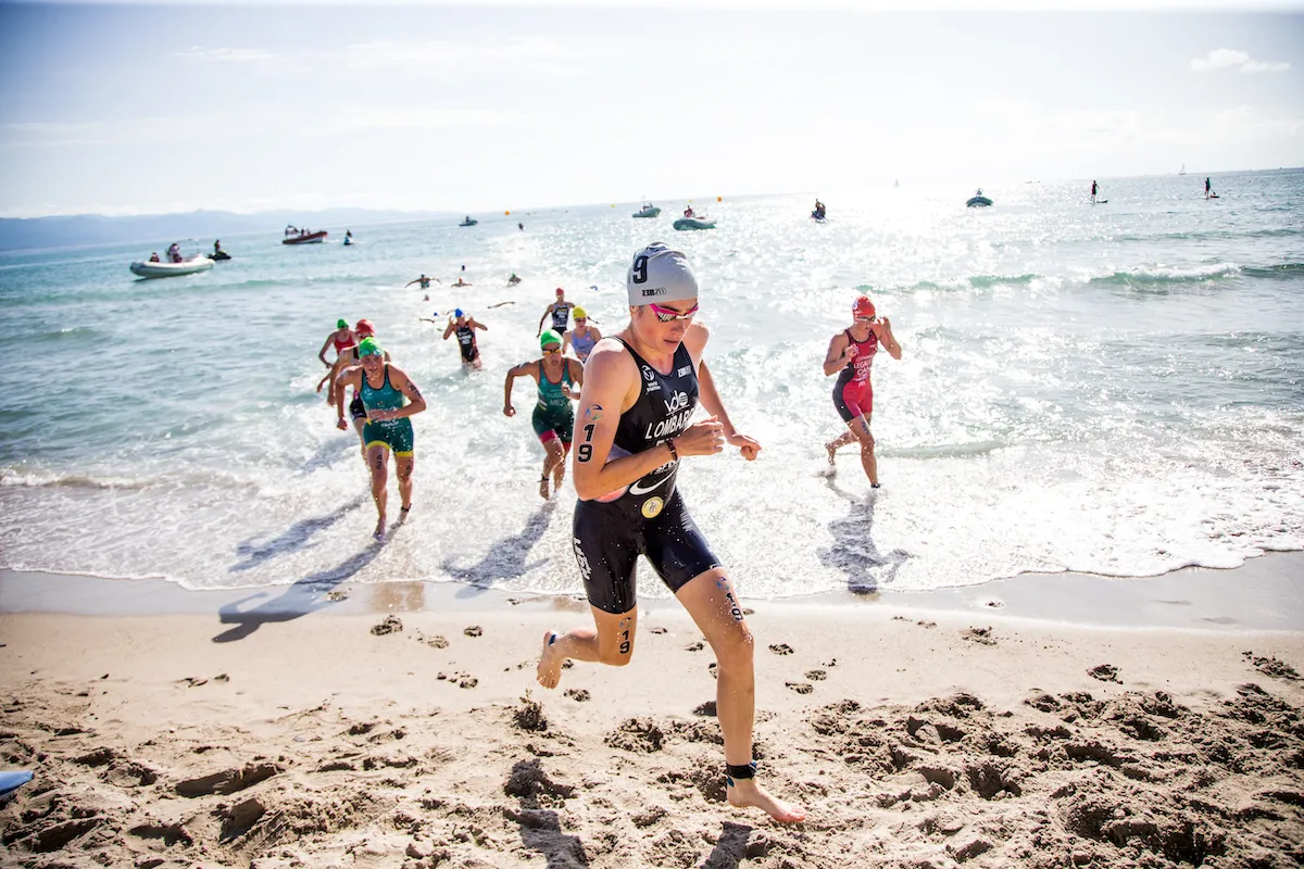 French triathlete Emma Lombardi runs out of the swim on the beach at the 2022 Cagliari WTCS race