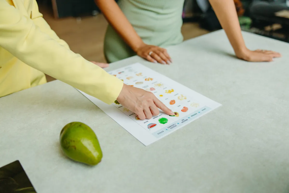 Person pointing to healthy eating information sheet on a table