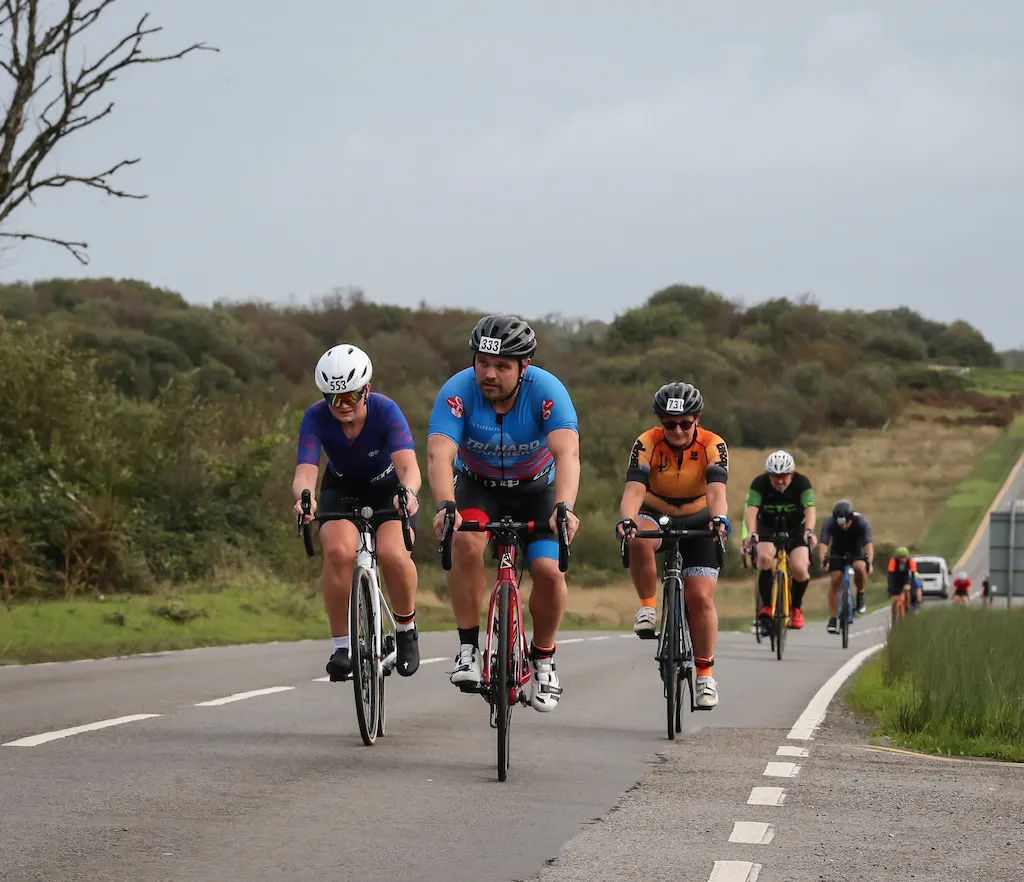 Image of cyclists heading towards the camera on a long street of road at the 2023 Mumbles Triathlon