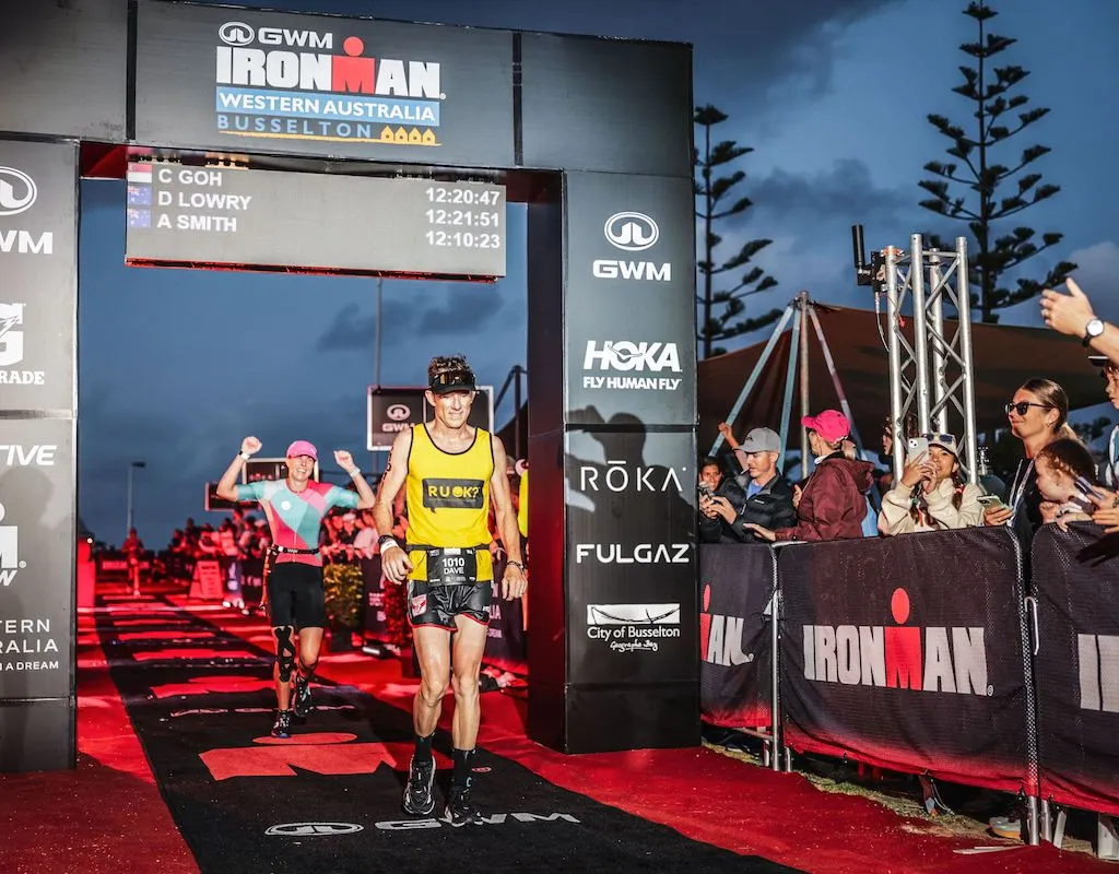 Dave Lowry crosses under the finish line gantry at Ironman Western Australia 