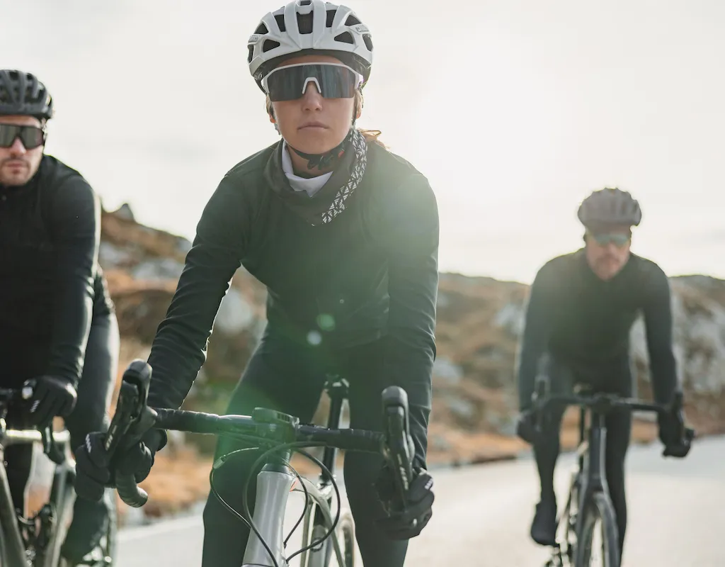 A group of male and female cyclists in winter bike kit tackling some mountainous terrain