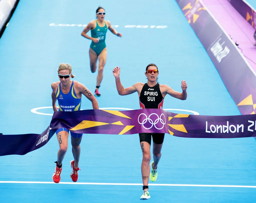 Lisa Norden and Nicola Spirig break the tape together at the 2012 London Olympics women's triathlon race