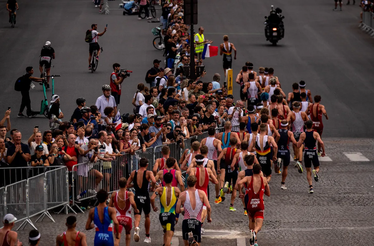 The pro men run past huge crowds along the cobbled streets of Paris at the Paris Olympics triathlon test event in 2023 