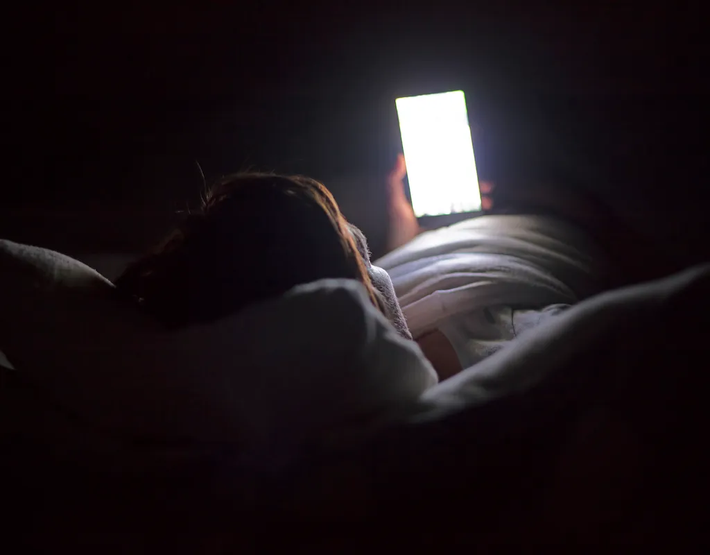 Woman using smartphone late at night