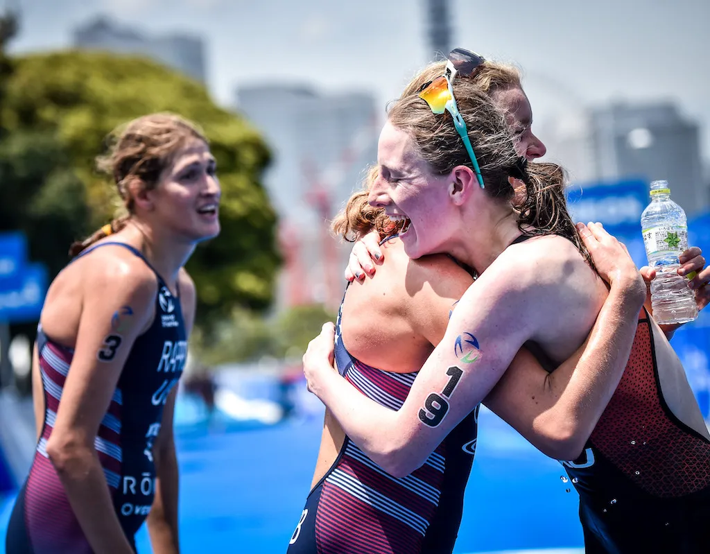 Dutch triathlete Maya Kingma, right, celebrates her first-ever WTCS medal, a bronze, in Yokohama, by embracing winner Taylor Knibb. Silver medallist Summer Rappaport is on the left