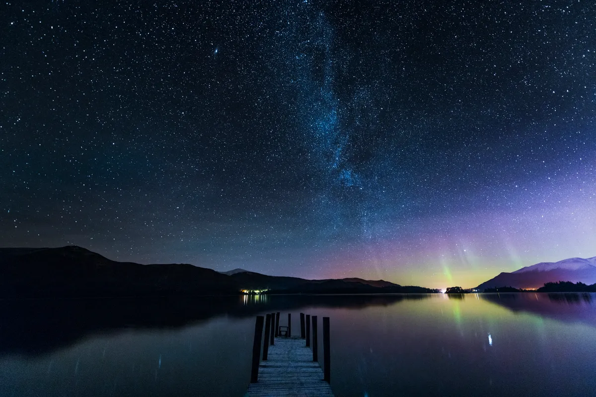 The Milky Way and Aurora Borealis from a jetty over Derwent water, Lake District