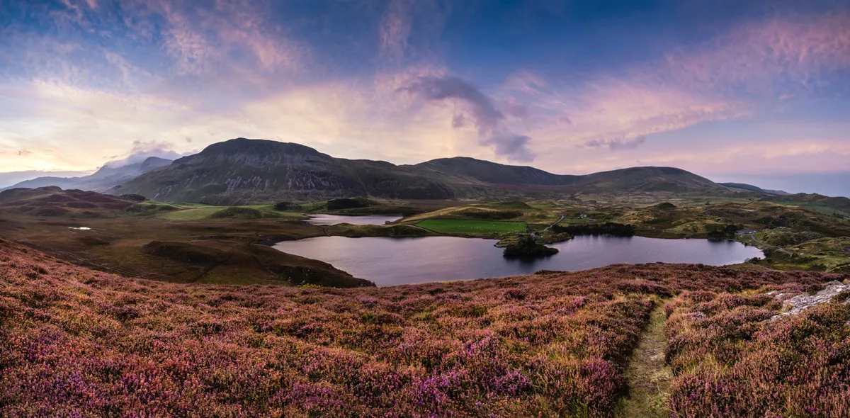 Stunning sunrise landscape over Cregennen Lakes with Cadair Idris in background in Snowdonia