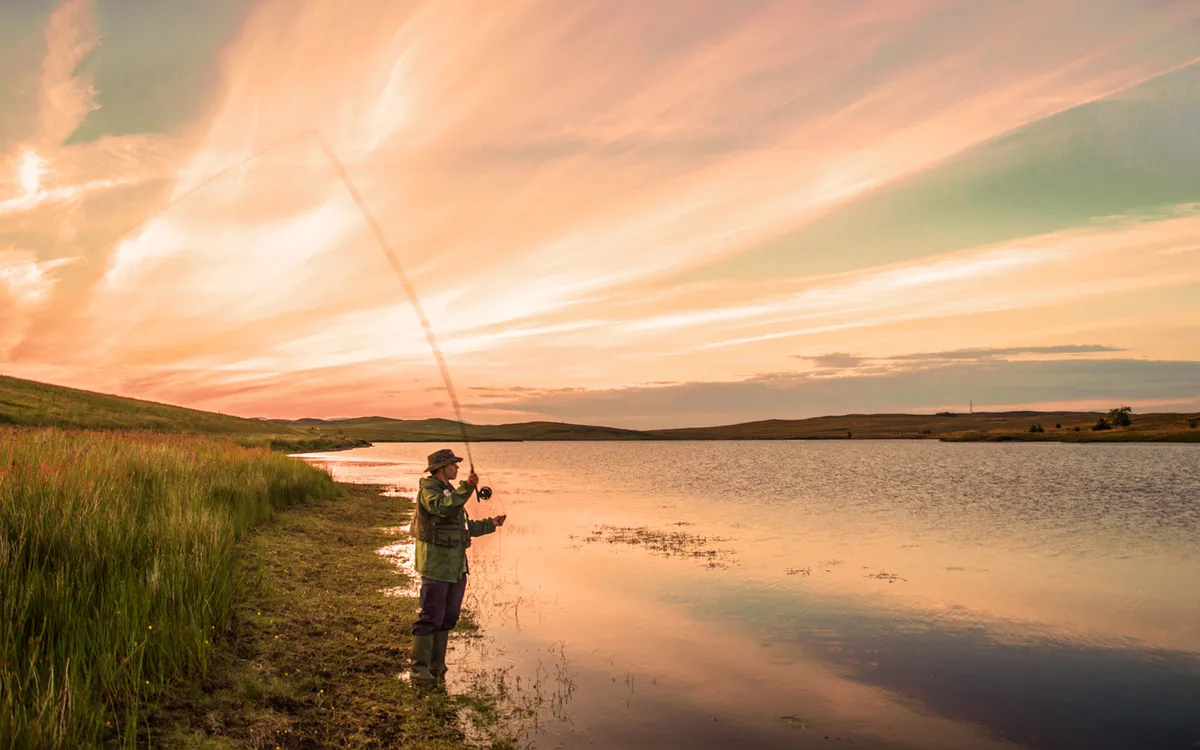 Man fishing at sunset in a lake