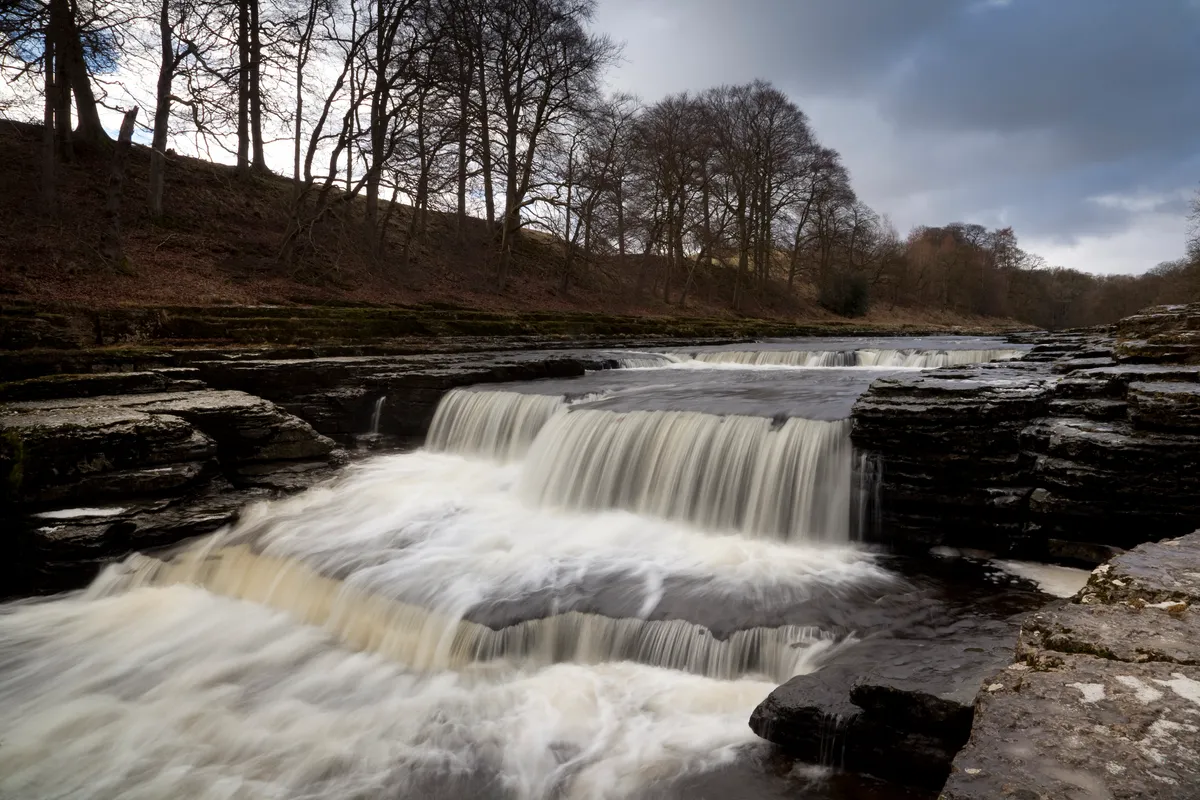 The River Ure flows over the Lower Falls of Aysgarth Falls, Wensleydale, Yorkshire, England