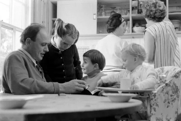 British author Roald Dahl (1916 - 1990) reads to three of his children, from left, Tessa, Theo, and Ophelia, in the kitchen of his home, Great Missenden, Buckinghamshire, England, September 1965. Teh two women in the background are unidentified. (Photo by Leonard McCombe/The LIFE Picture Collection/Getty Images)