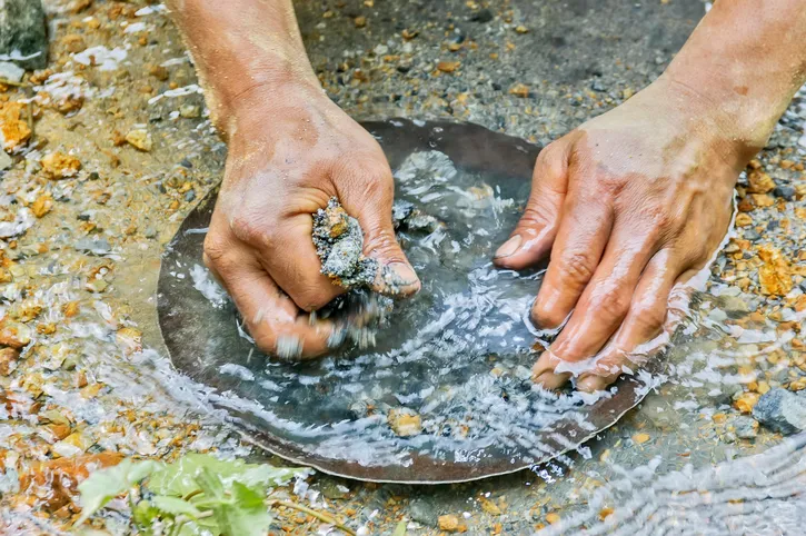 Closeup of hands gold panning in a river