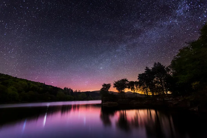This photograph was taken at Burrator Reservoir in Dartmoor National Park. The picture was captured at night and shows the Milkyway and starry sky over the calm reservoir water. Dartmoor is a popular tourist destination as well as one of the best locations in the country for stargazing.