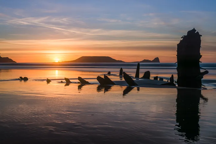The remains of the Norwegian barque Helvetia and Worm's Head are probably the most photographed points of interest on the whole Gower Peninsula, South Wales. They can be found in Rhossili Bay, and can both be seen in this photography.