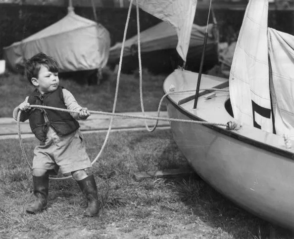 17th April 1952: 2-year-old Simon Maddison, complete with life-jacket and gum boots, helps his father prepare their Firefly Class yacht 'Transient' for the forthcoming yacht race on the Thames. (Photo by Harry Todd/Fox Photos/Getty Images)