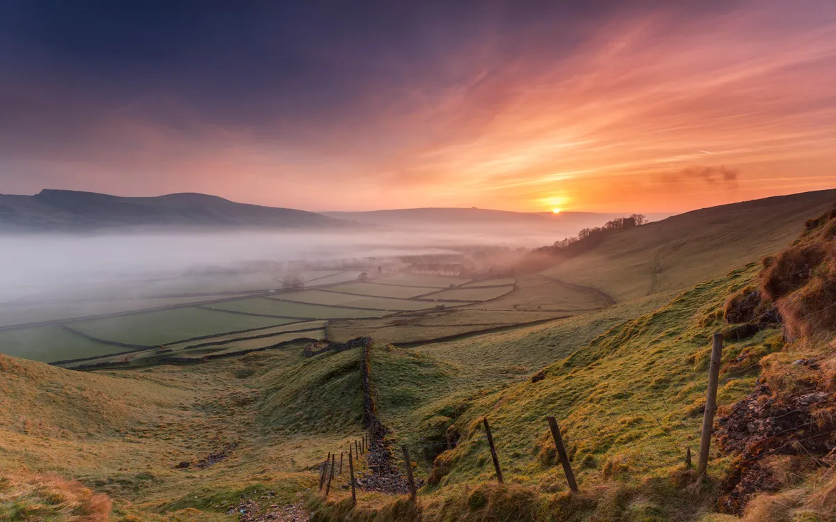 sunrise and mist over a countryside landscape