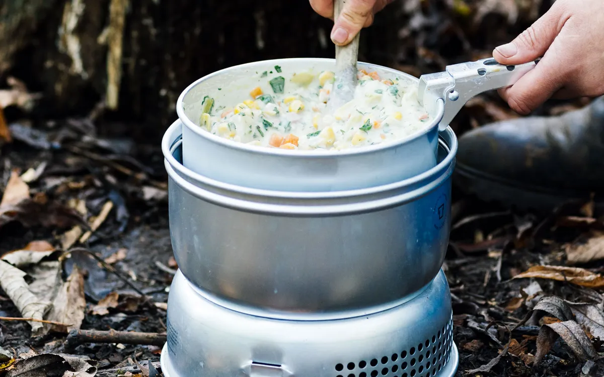 Vegetable and bacon chowder in a camping stove