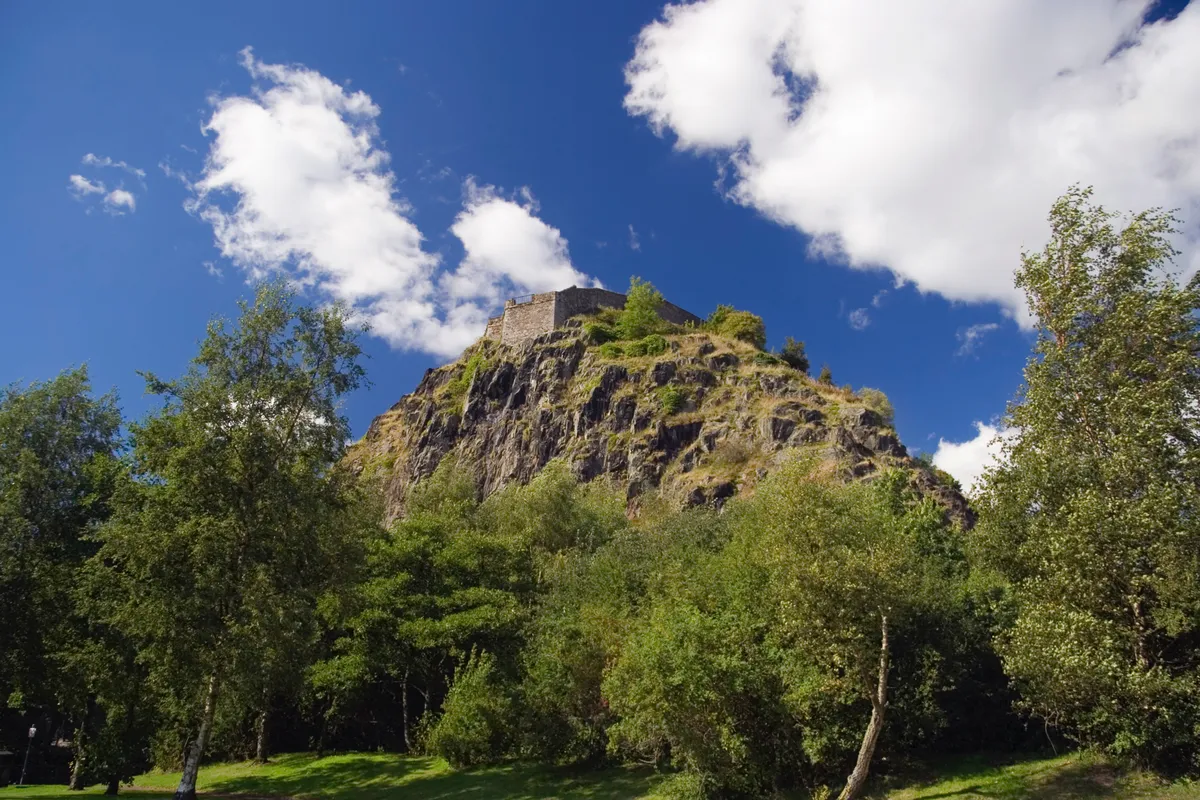 Dumbarton Castle at the top of a cliff surrounded by trees