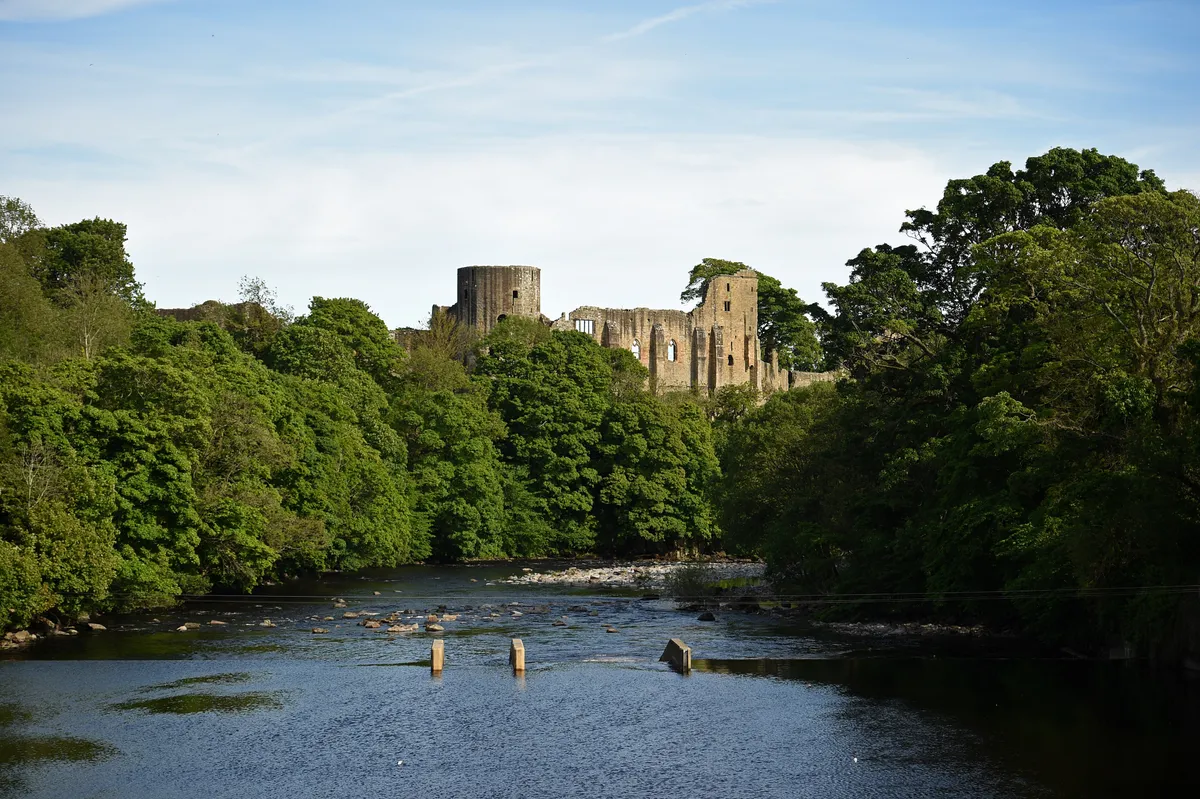 Ruins of a castle with a river in the foreground